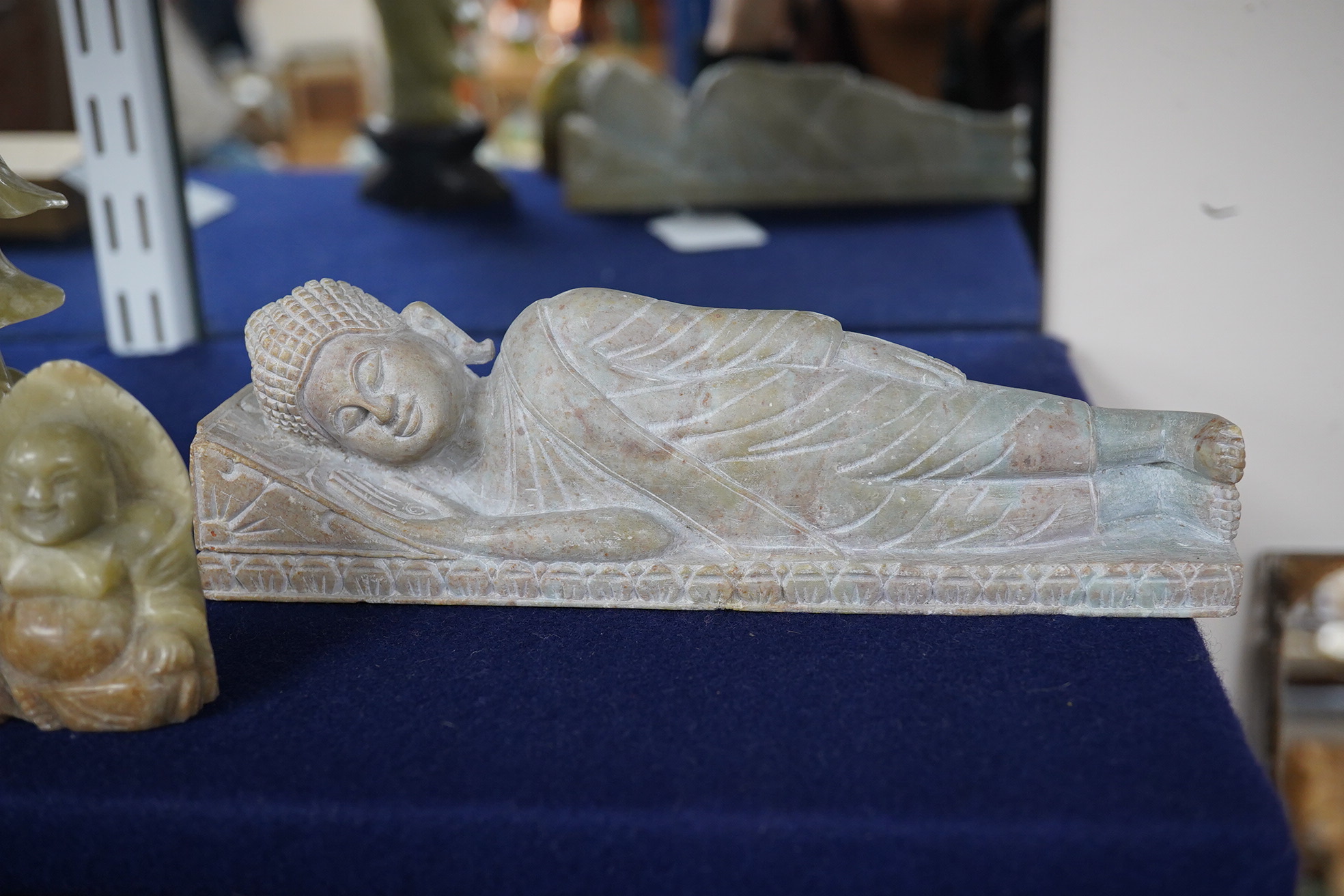 A carved stone reclining buddha, a Chinese deity and a seated buddha, largest 20cm wide. Condition - fair to good